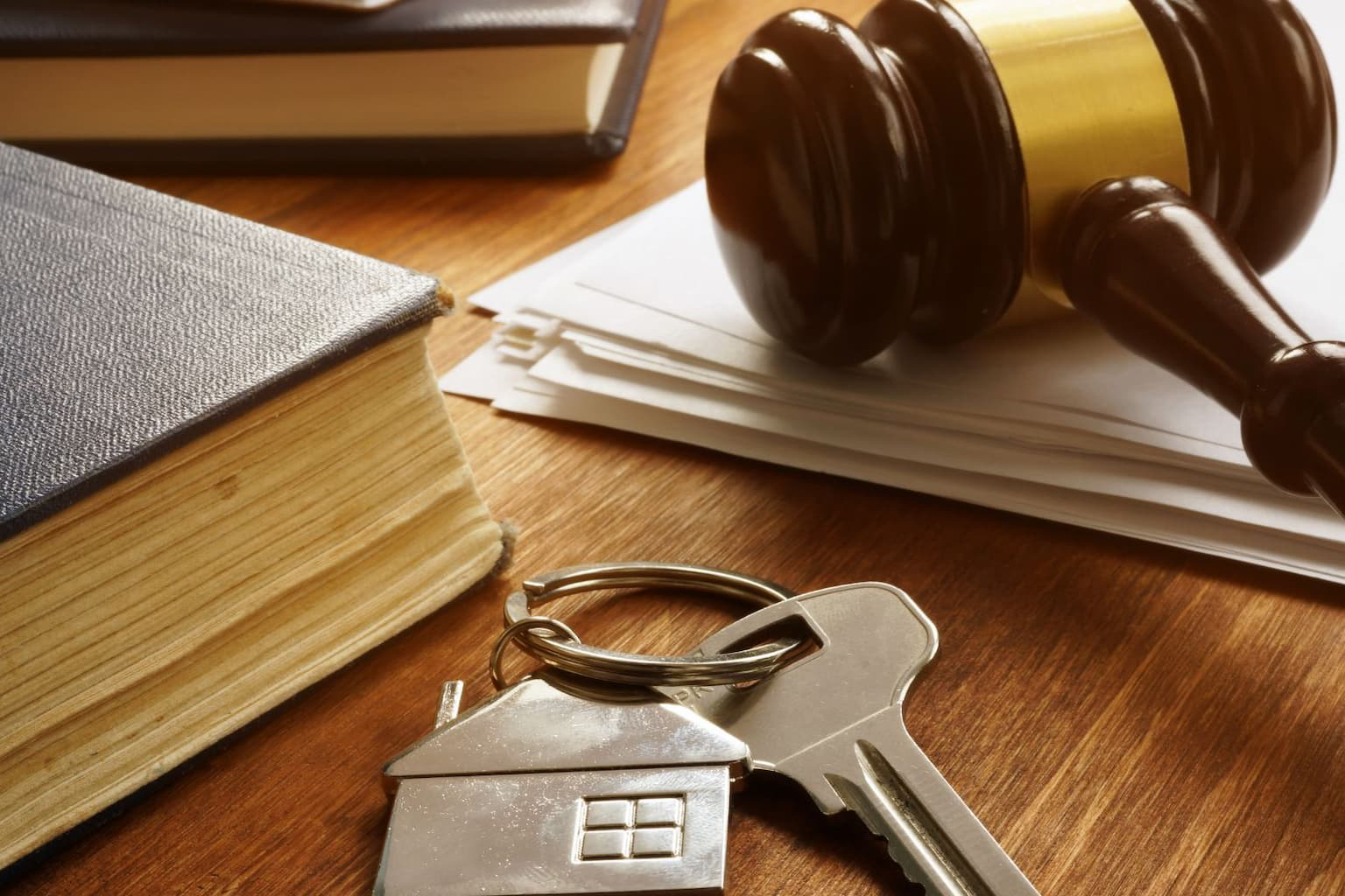 Court gavel next to estate documents and home keys