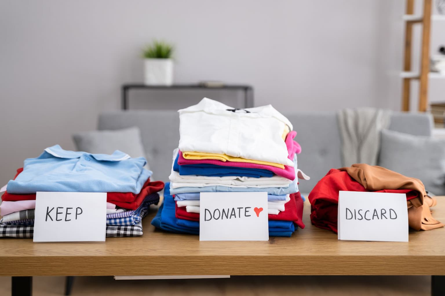 Boxes labeled keep, donate, discard, and recycle during hoarder home decluttering process