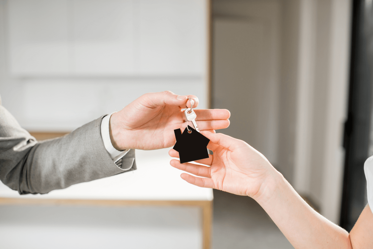 Landlord handing keys to buyer with tenants nearby