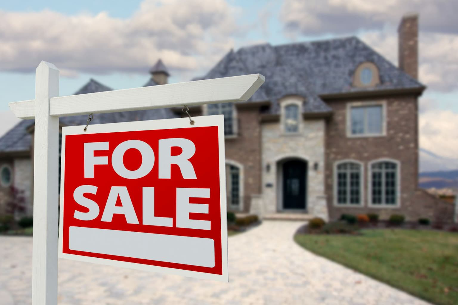 “For Sale” sign in front of a house