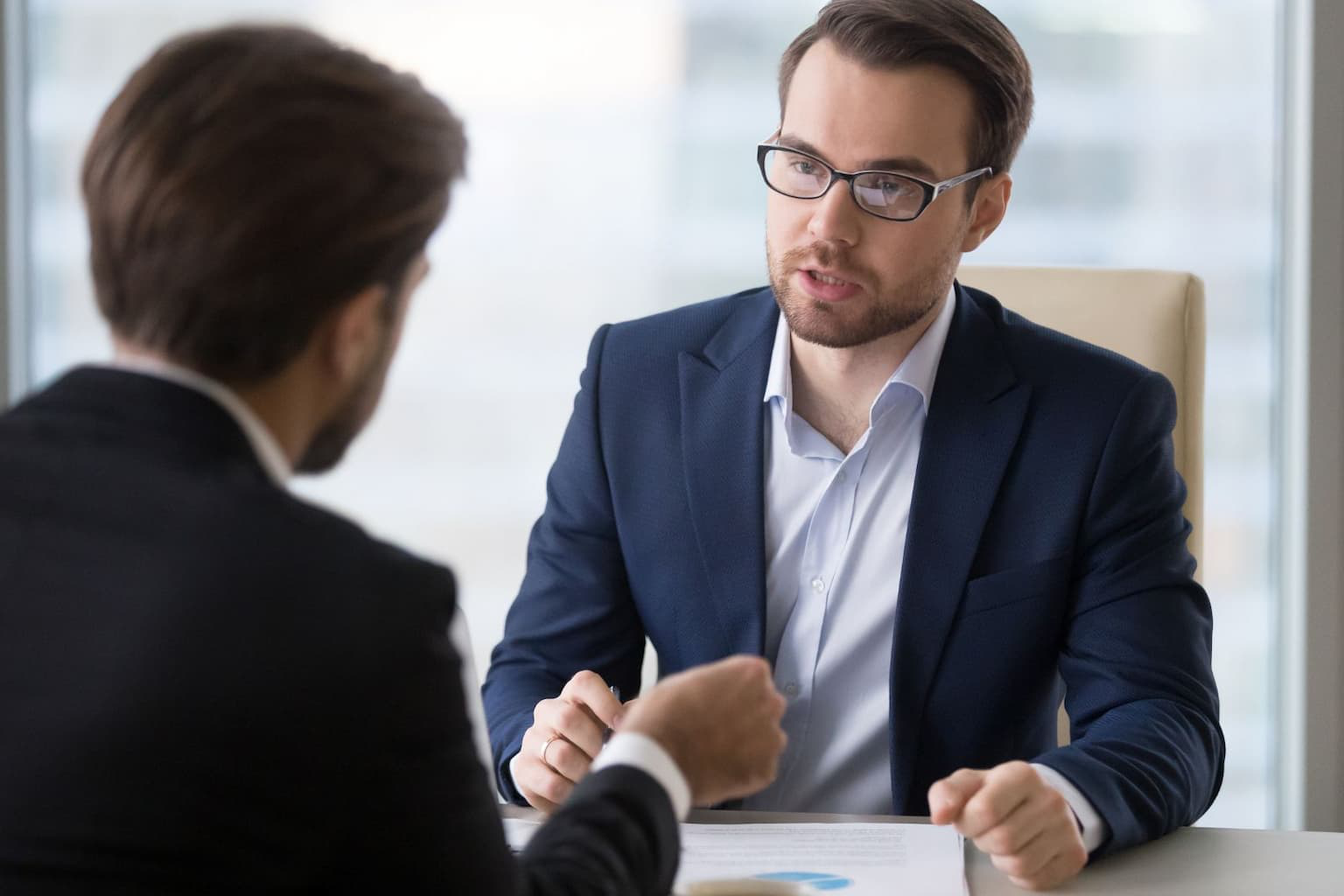Man sitting at a desk during a meeting, discussing loan terms or foreclosure options with a lender