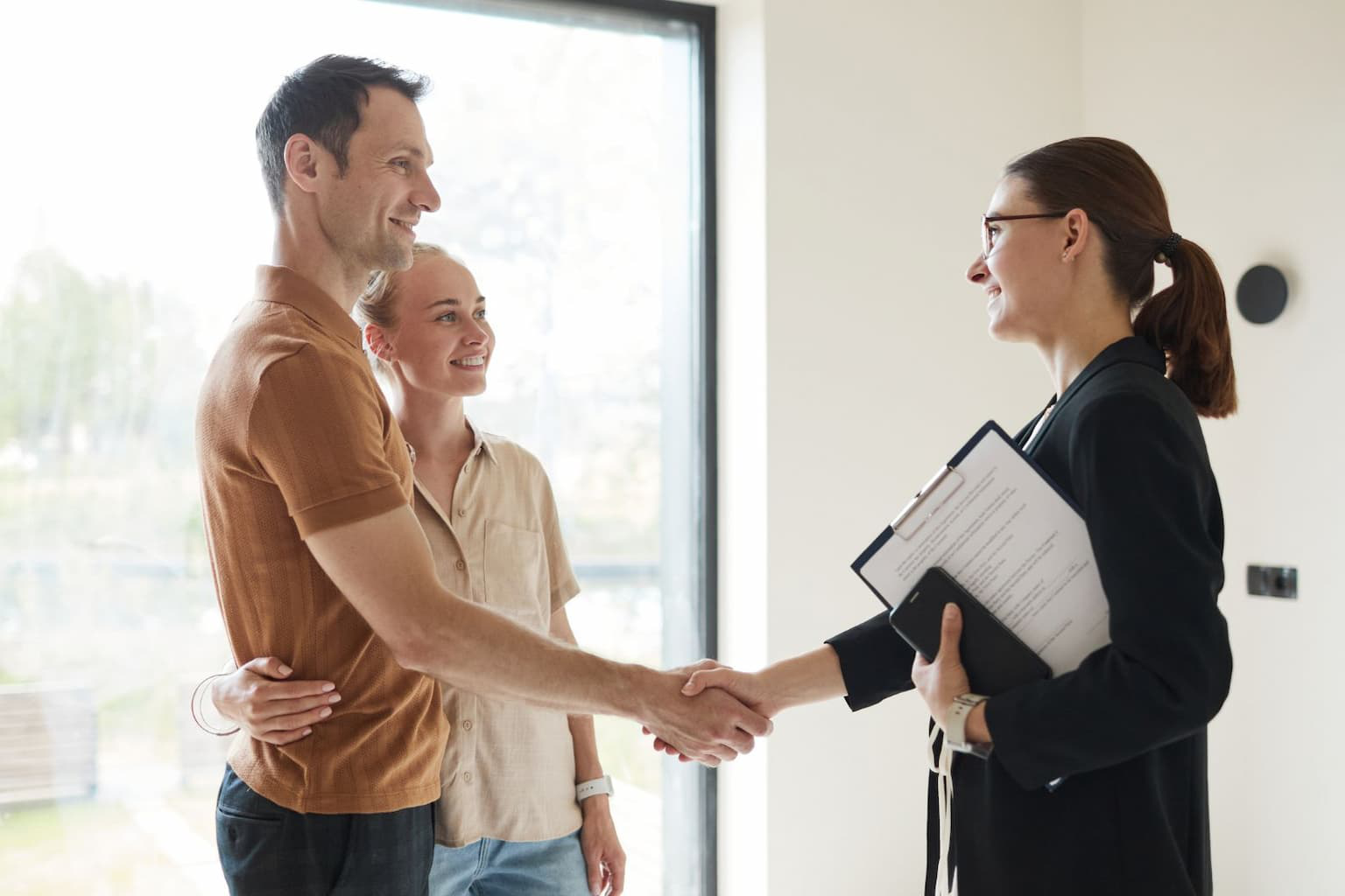 Handshake between a homeowner and a real estate investor outside a property, indicating a cash sale deal