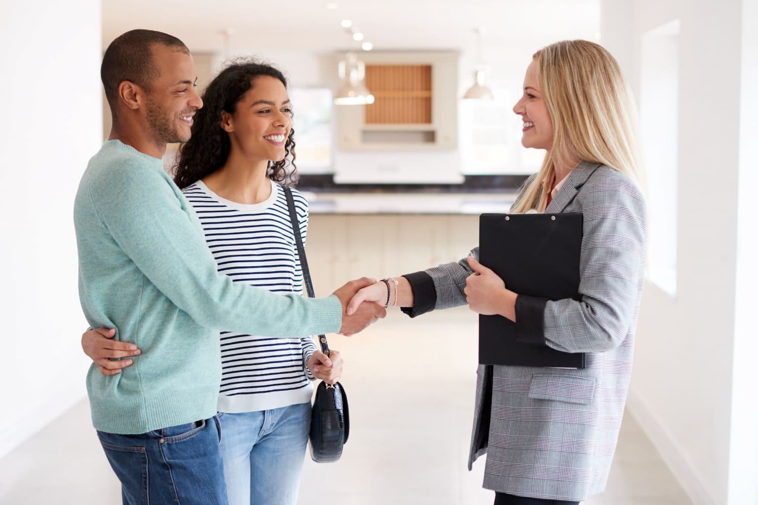 Investor shaking hands with seller in front of house