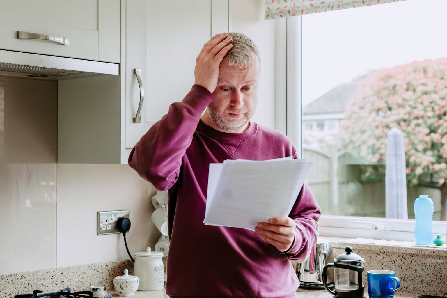 Stressed homeowner looking at bills and mortgage documents