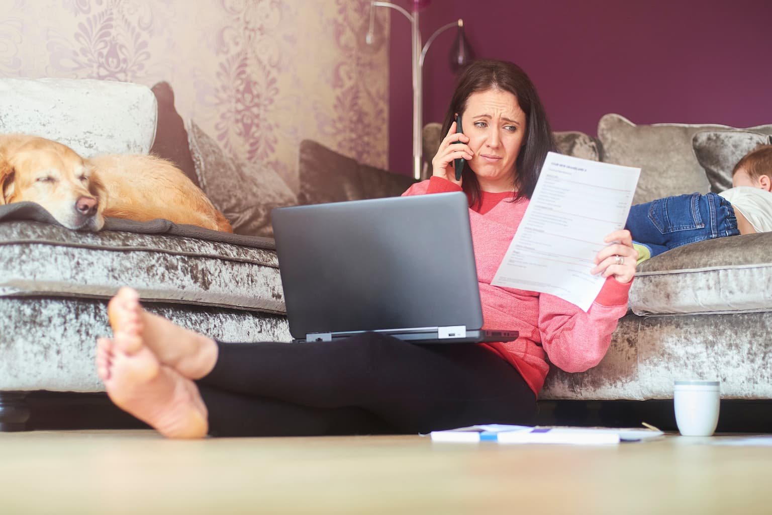 Worried homeowner making a phone call with mortgage papers