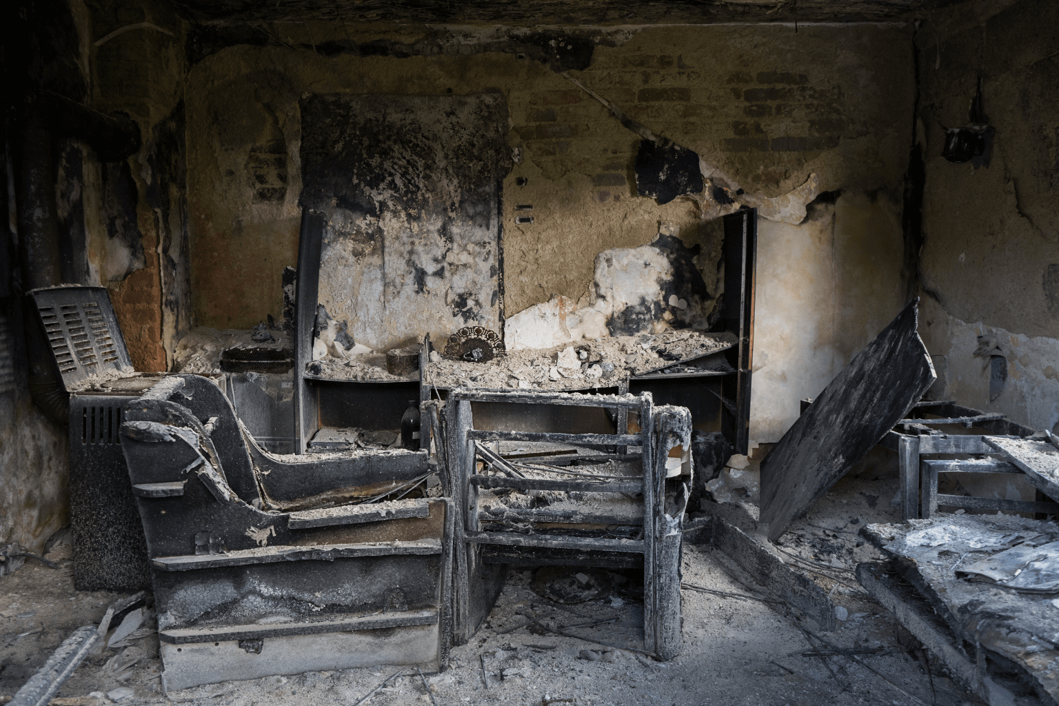 Fire-damaged living room with charred walls and debris