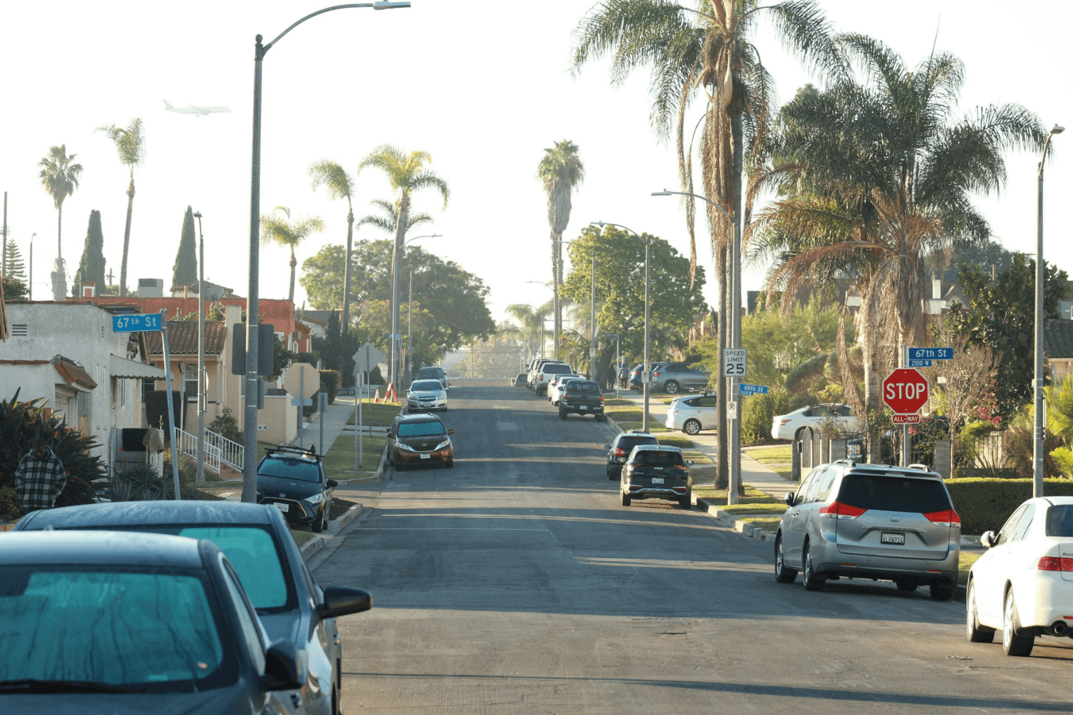 ree‑lined California neighborhood street with homes and parked cars
