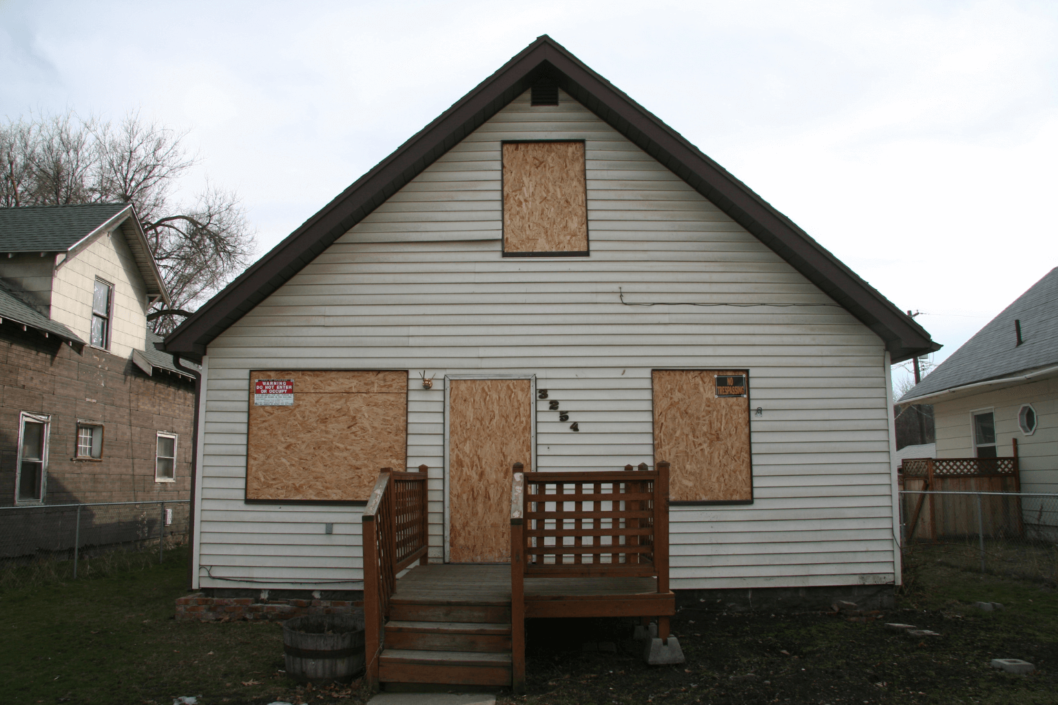 Old condemned house with broken windows and warning signs