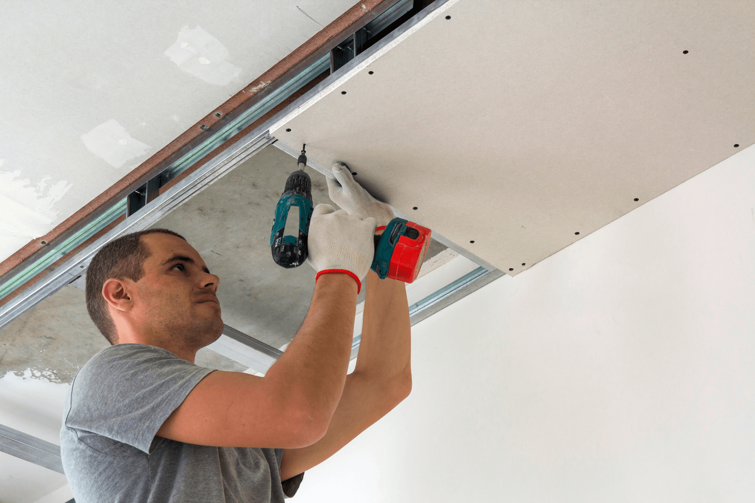 Contractor fixing drywall and flooring after flood