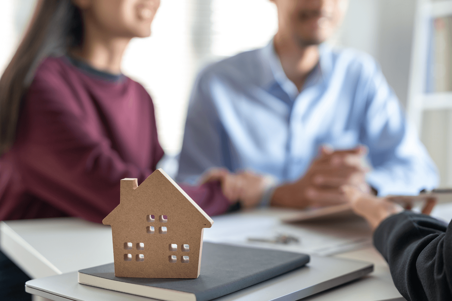 Man and woman talking to home-buying professional during divorce