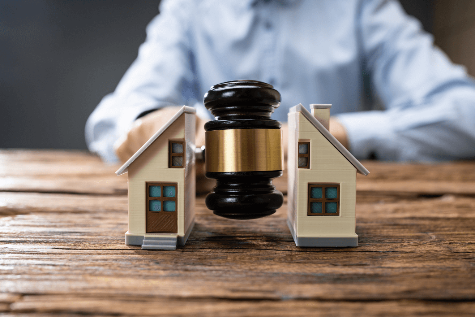 Gavel dividing a model house during divorce settlement
