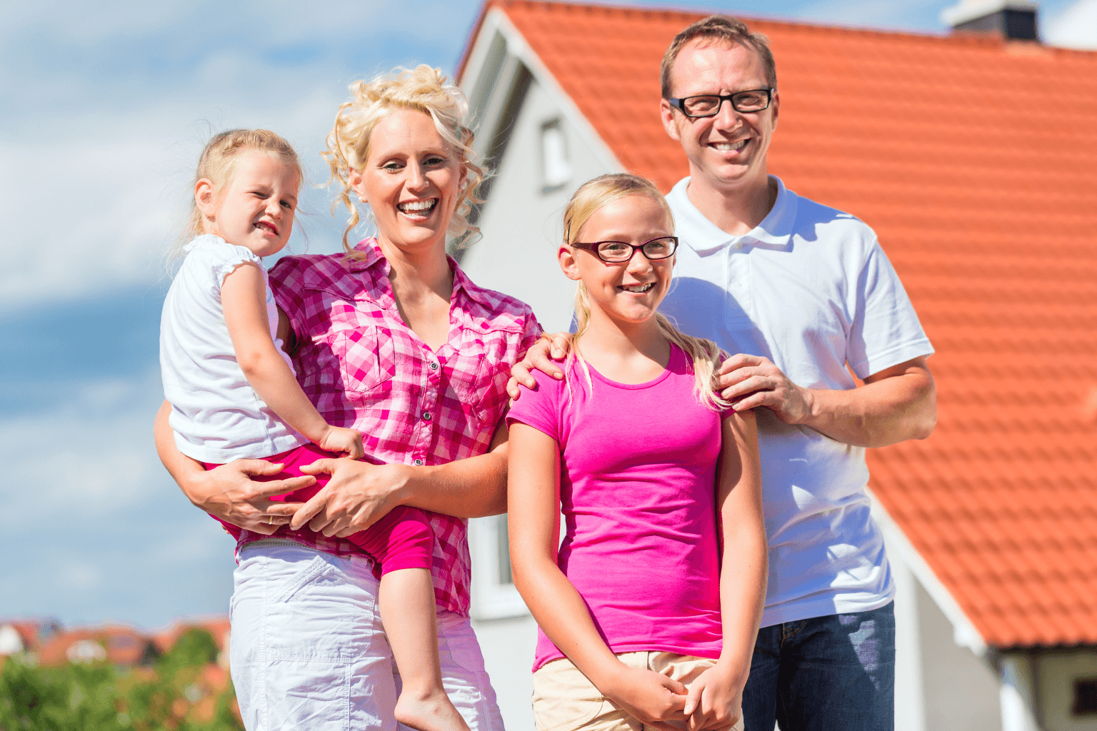 Smiling homeowner standing in front of their home