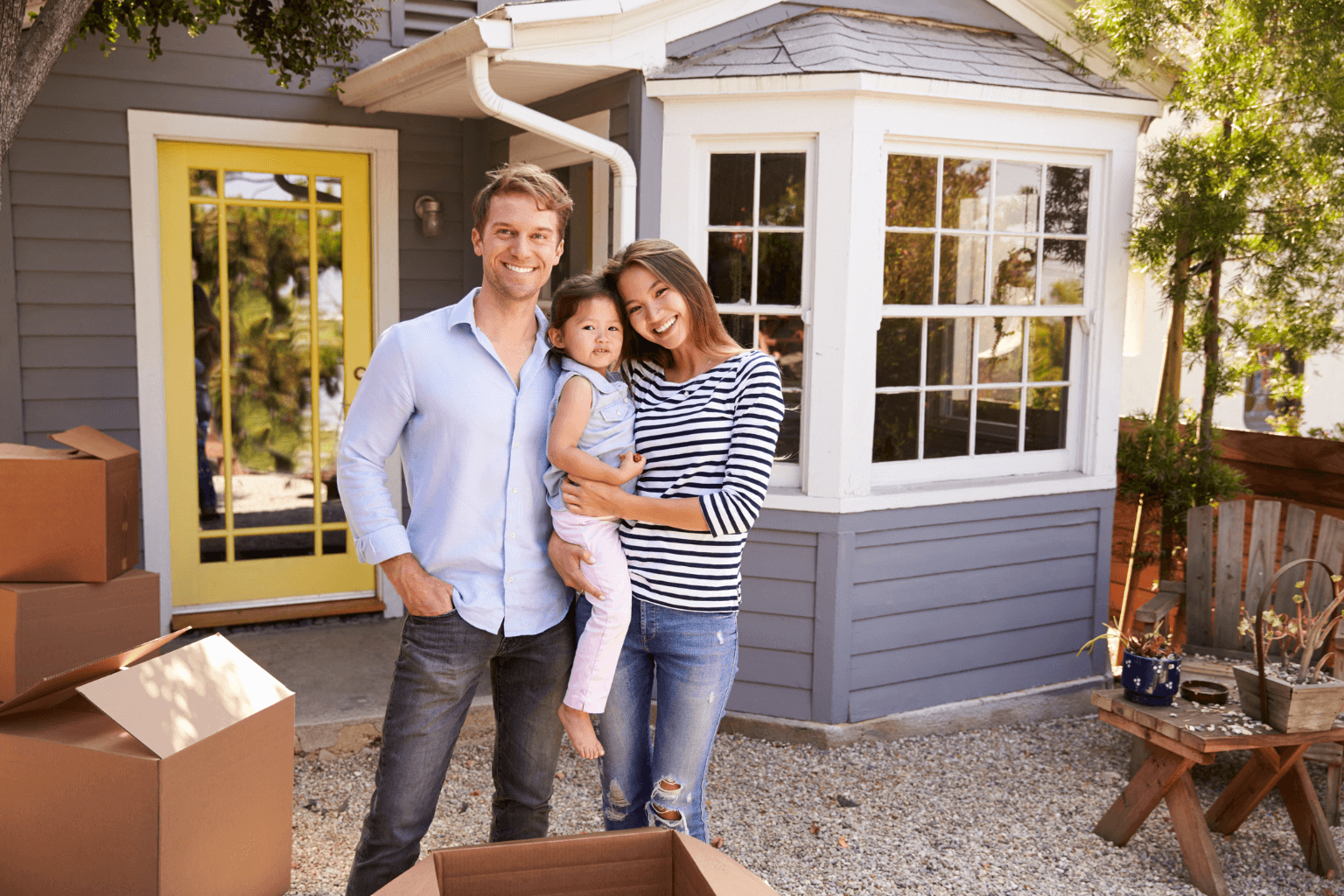 Happy family standing in front of their new home