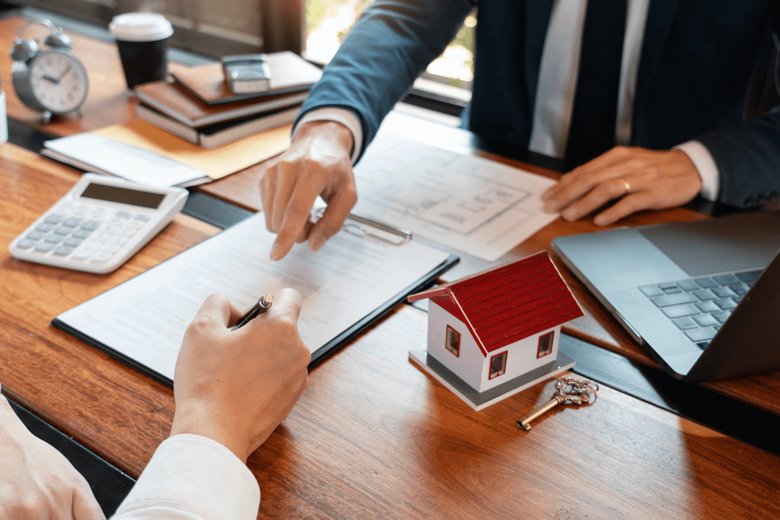 Legal documents and house keys on a wooden desk