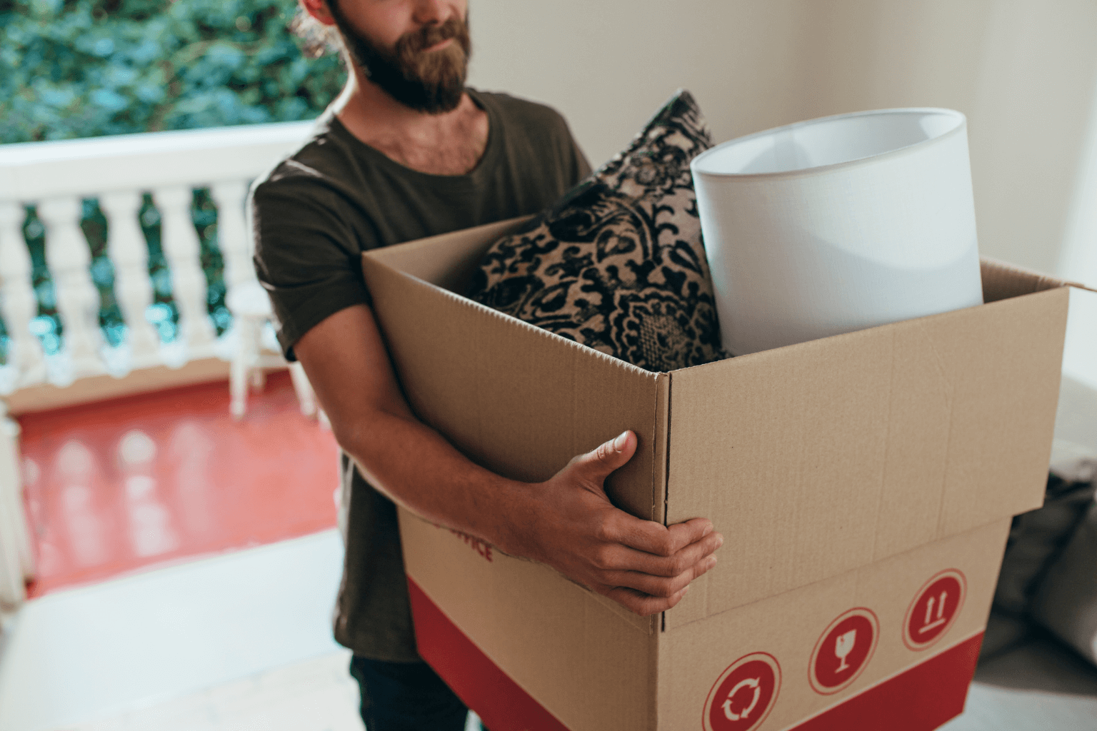Person carrying moving boxes into a new home