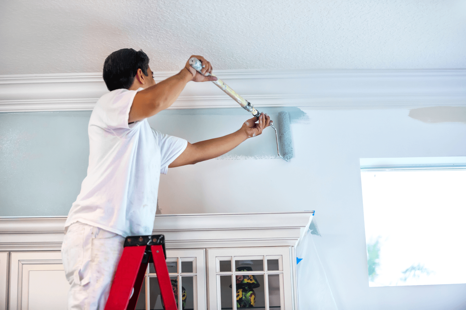 Person painting a wall to get a house ready to sell