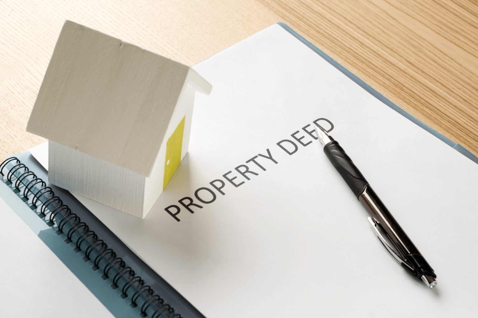 Close-up of a property deed and pen on a wooden desk