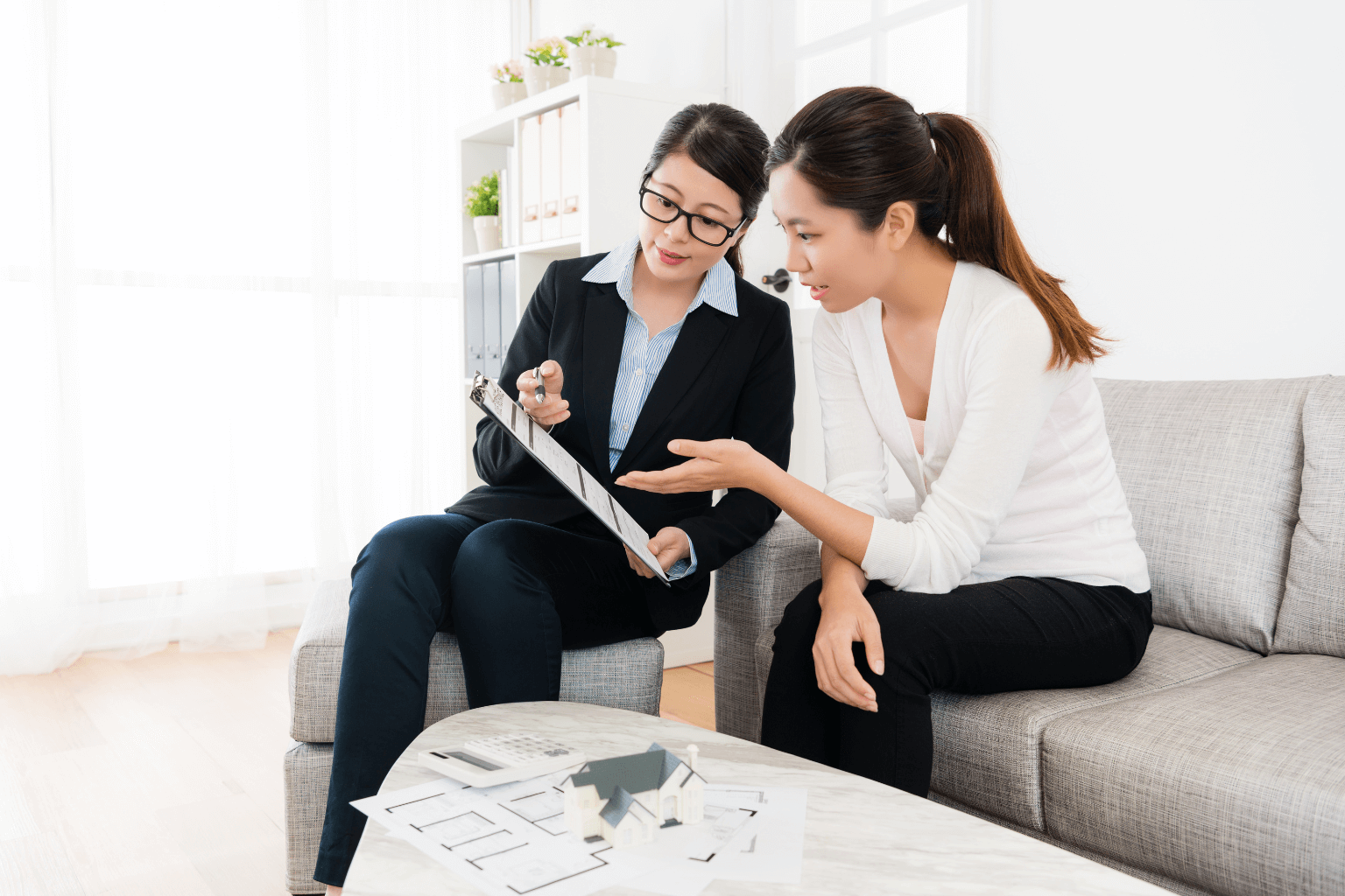 Real estate agent explaining paperwork to a couple selling a house