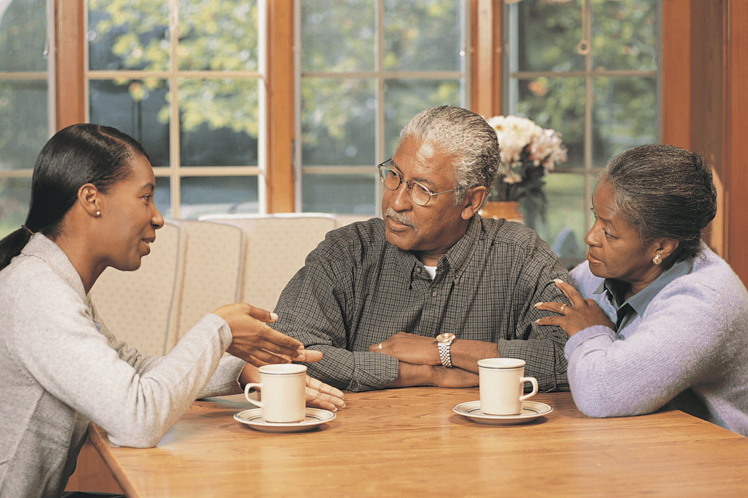 Siblings sitting around a table having a discussion about home sale