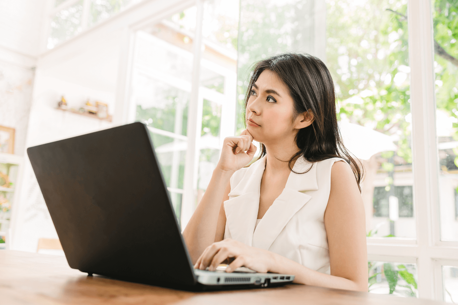Person thinking while sitting in front of a house or computer