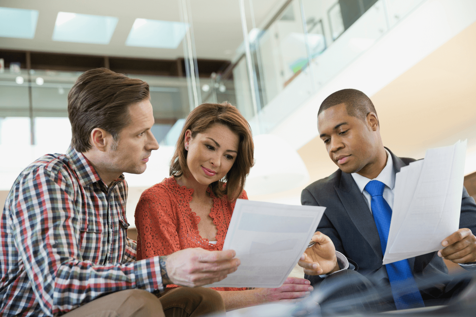 Couple reviewing home documents with real estate agent for Selling a Property with Solar Panel Leases