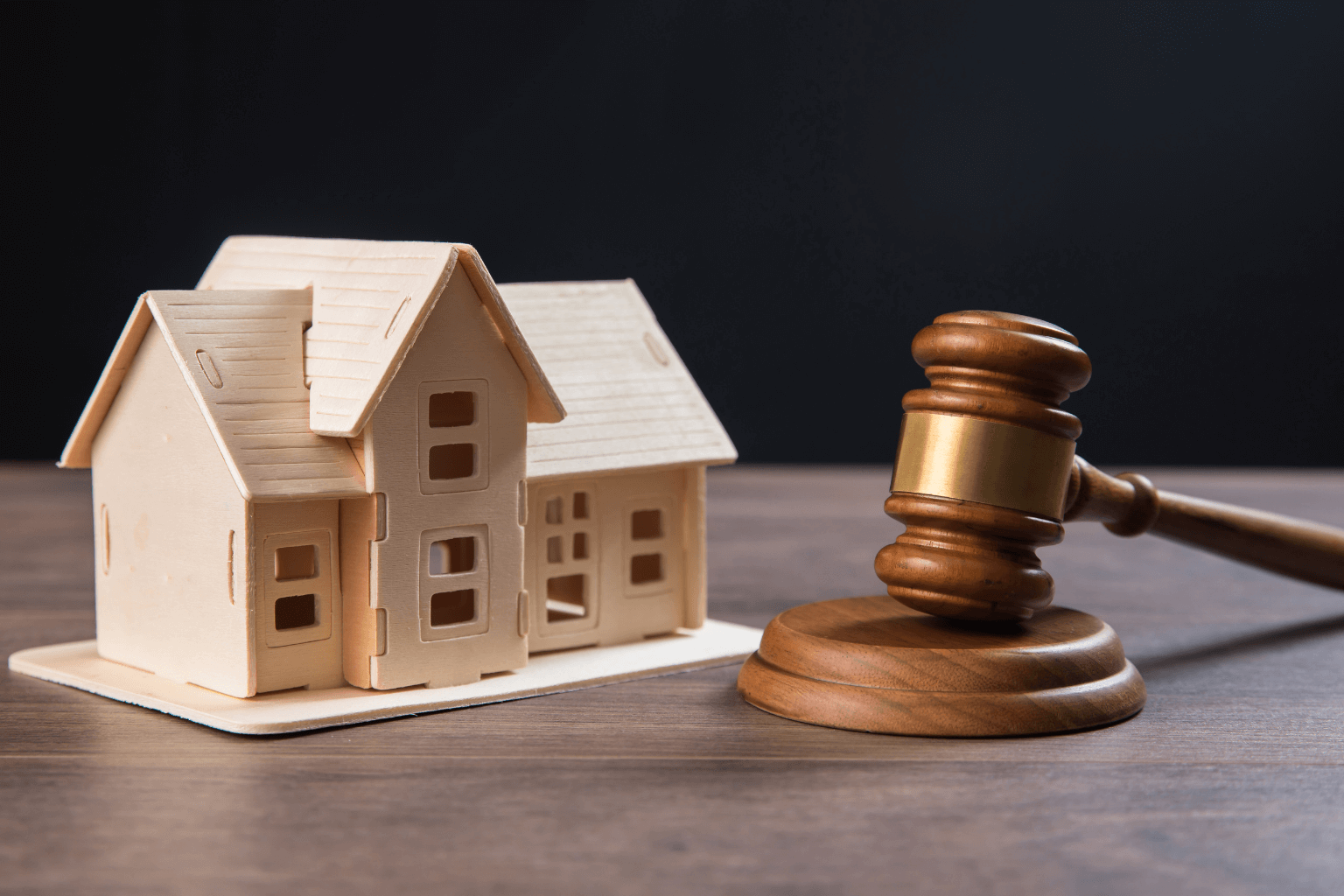 a judge’s gavel beside a home model
