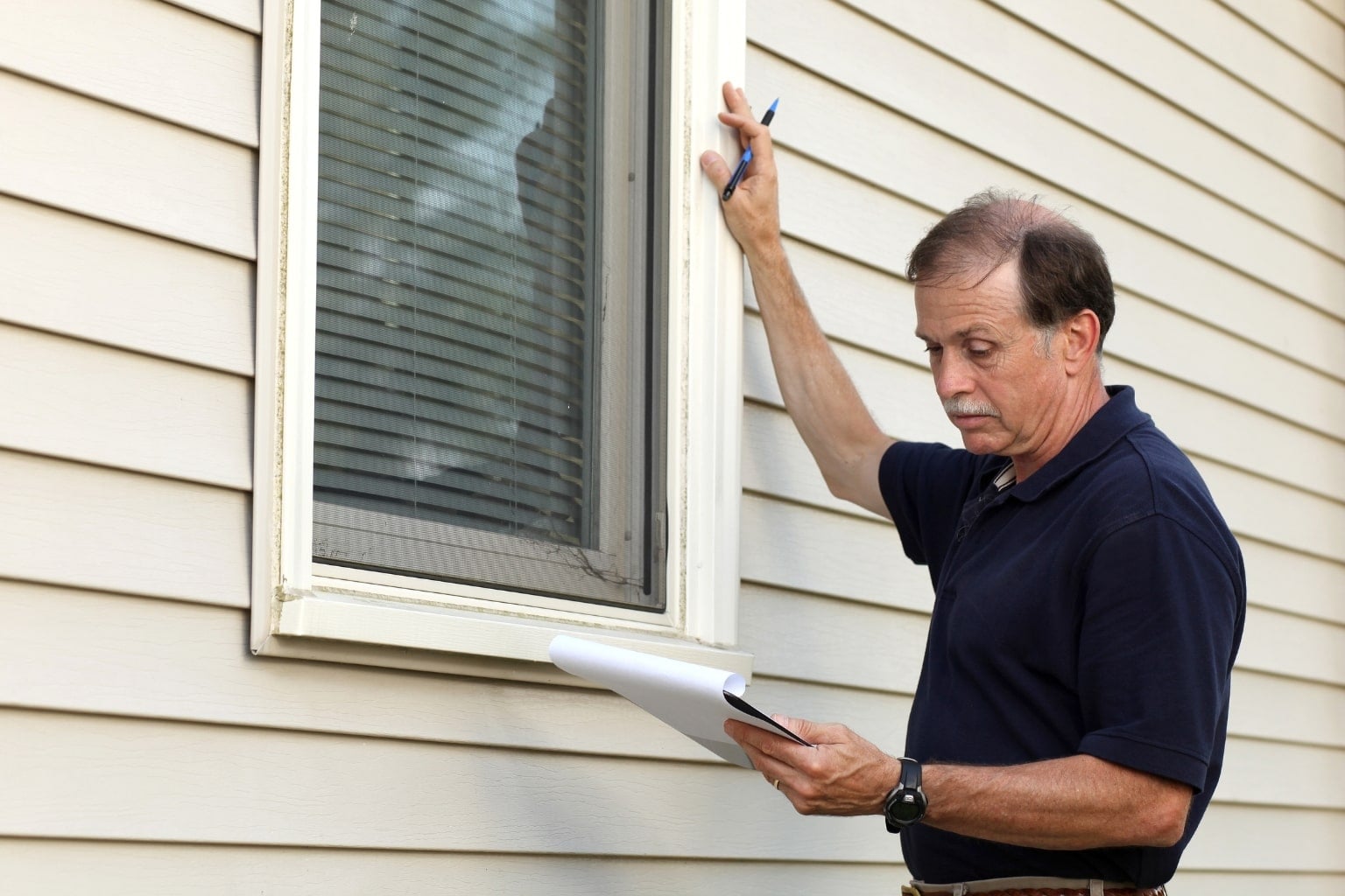 Home inspector examining a house exterior