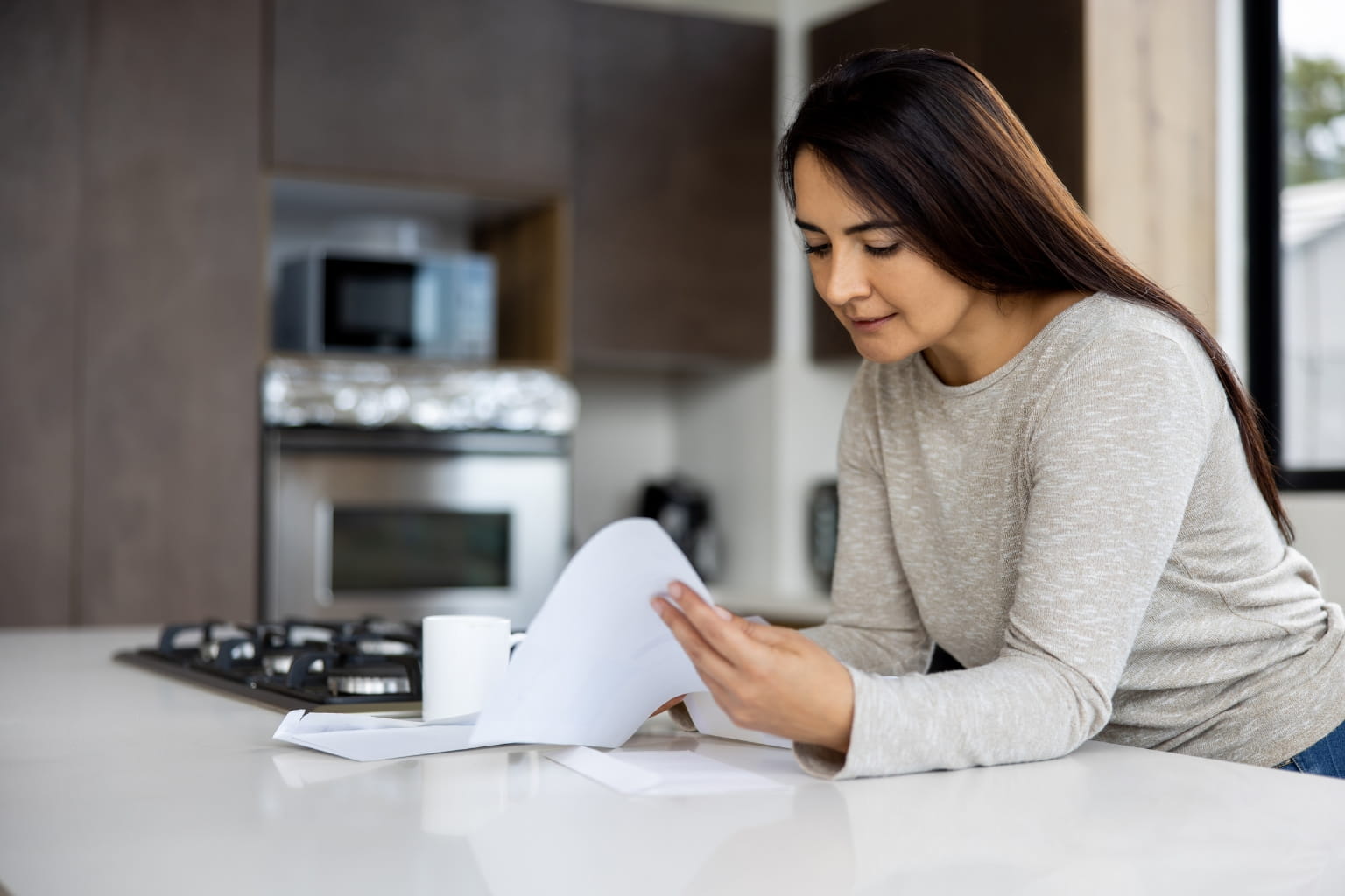 Person reviewing offer letter at kitchen table