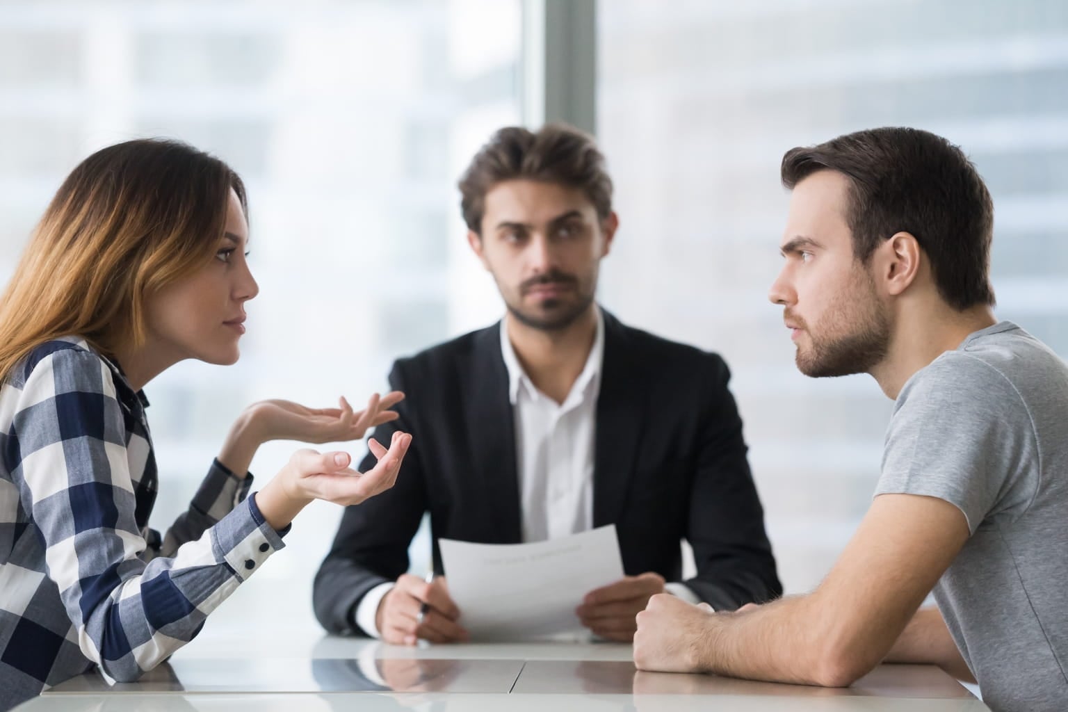 Divorcing couple discussing settlement with mediator or lawyer