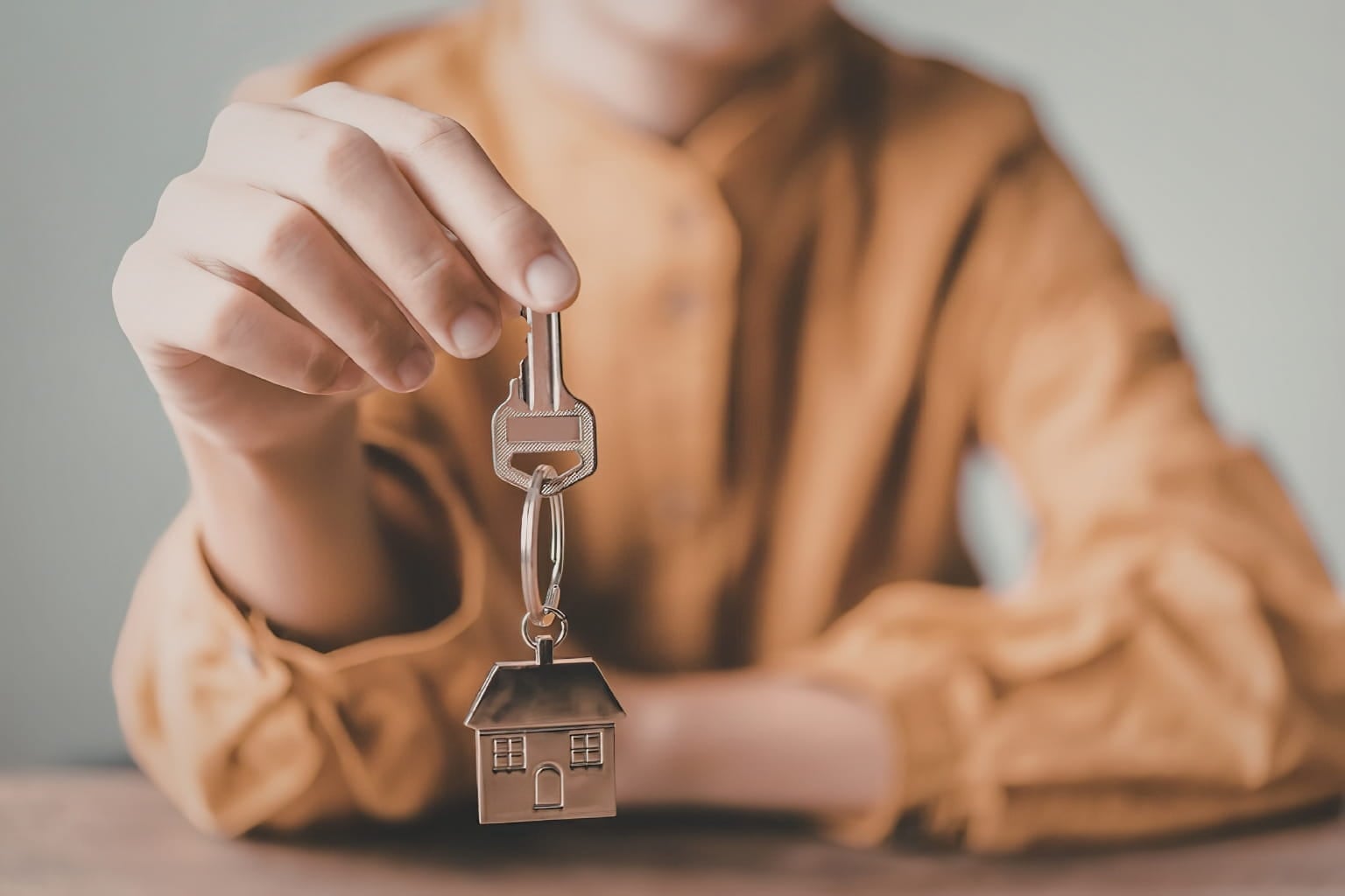 Hand holding a house key | How to Avoid Depreciation Recapture