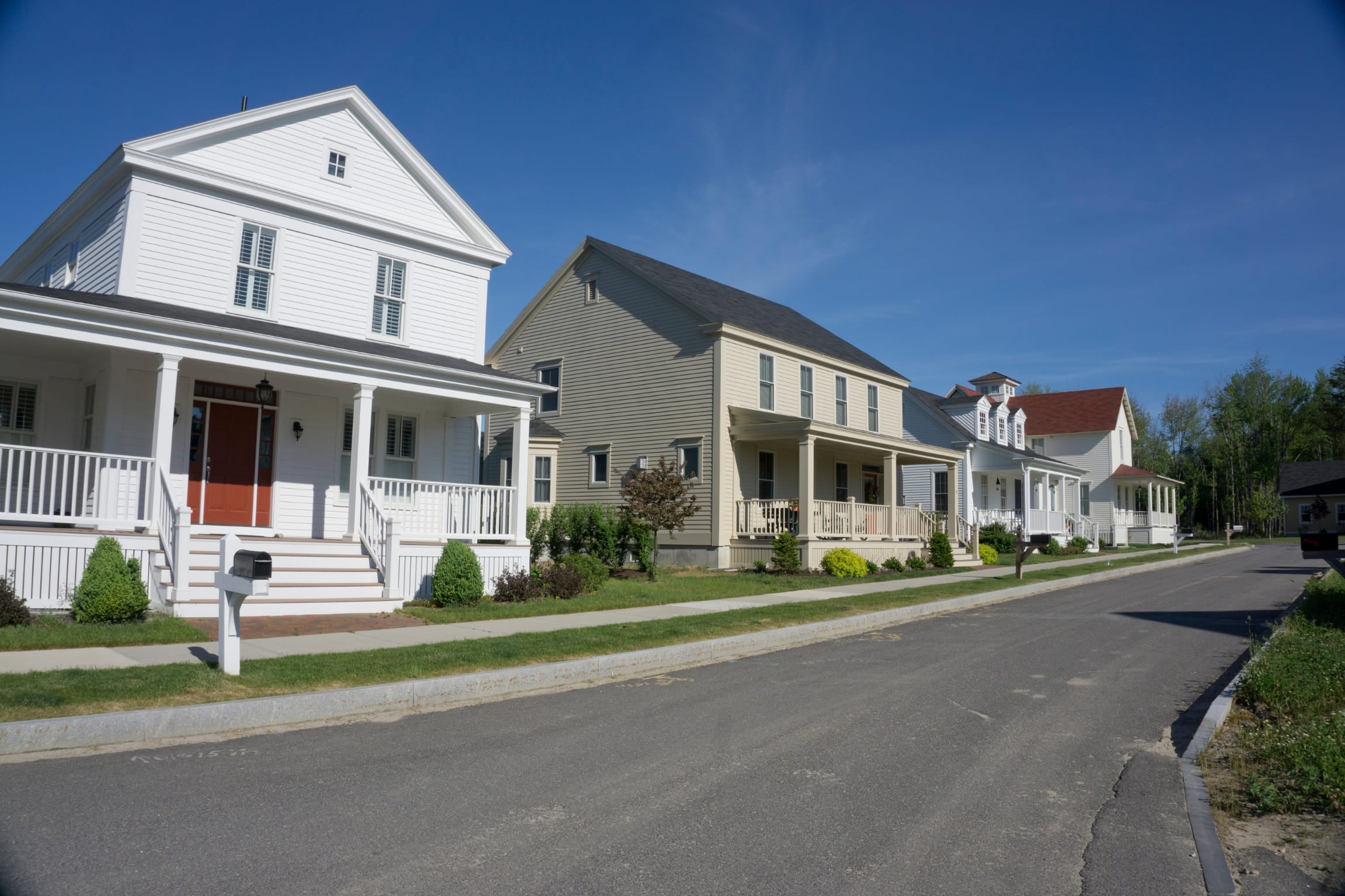 street view of a quiet suburban neighborhood with multiple homes, trees, and clean streets