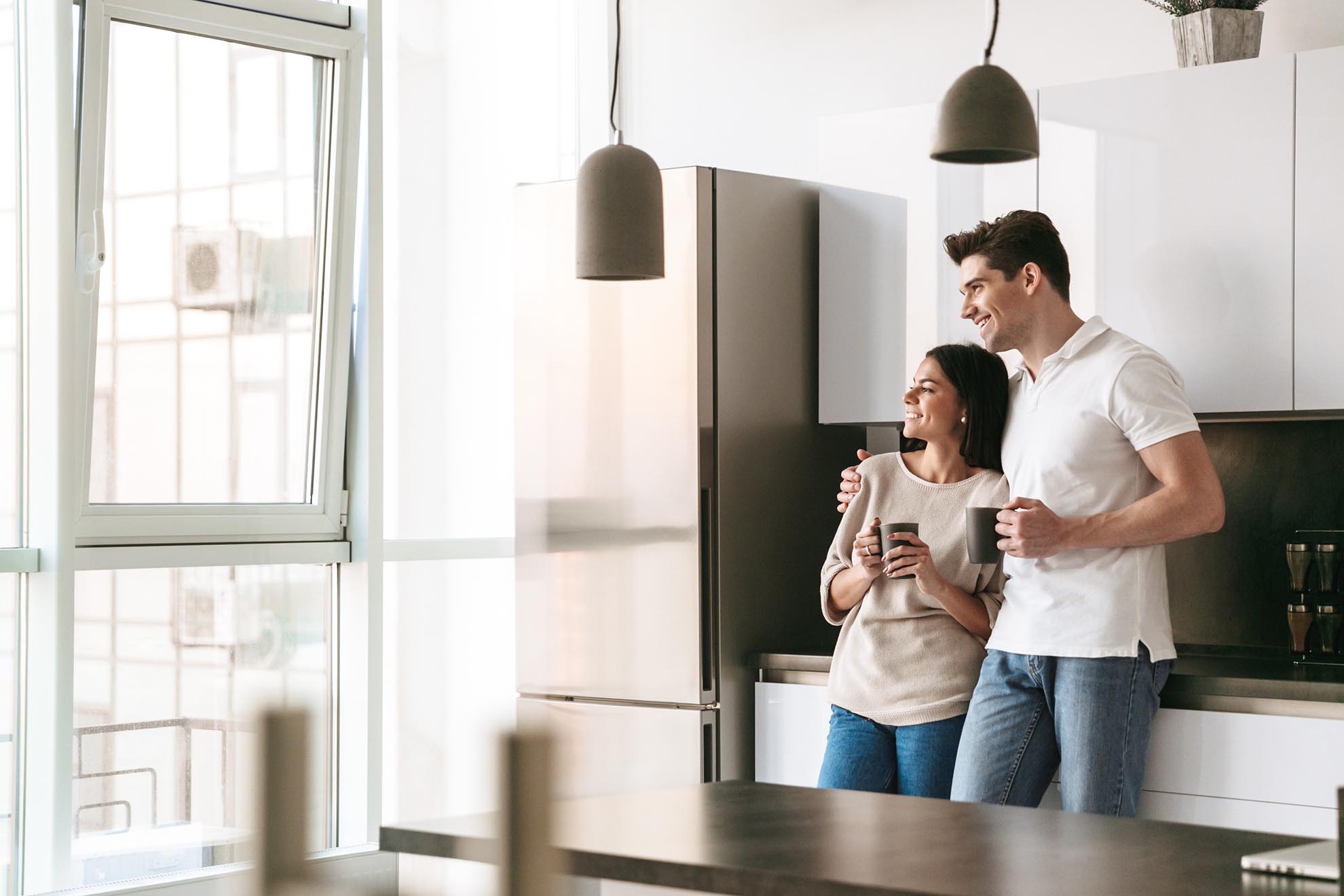 Happy lovely young couple holding cups