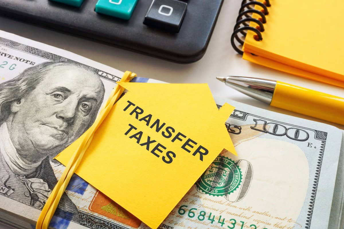 Outline-of-a-house-with-the-phrase-Transfer-Taxes-and-cash.-Real-estate-transactions