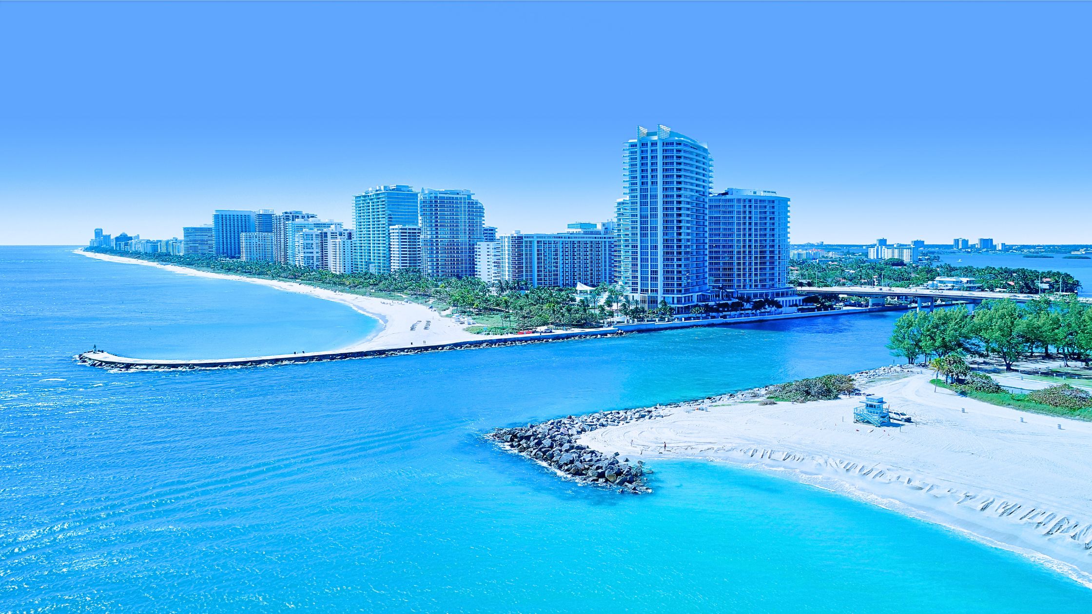 Luxury oceanfront condo towers and palms representing living in Bal Harbour Miami lifestyle