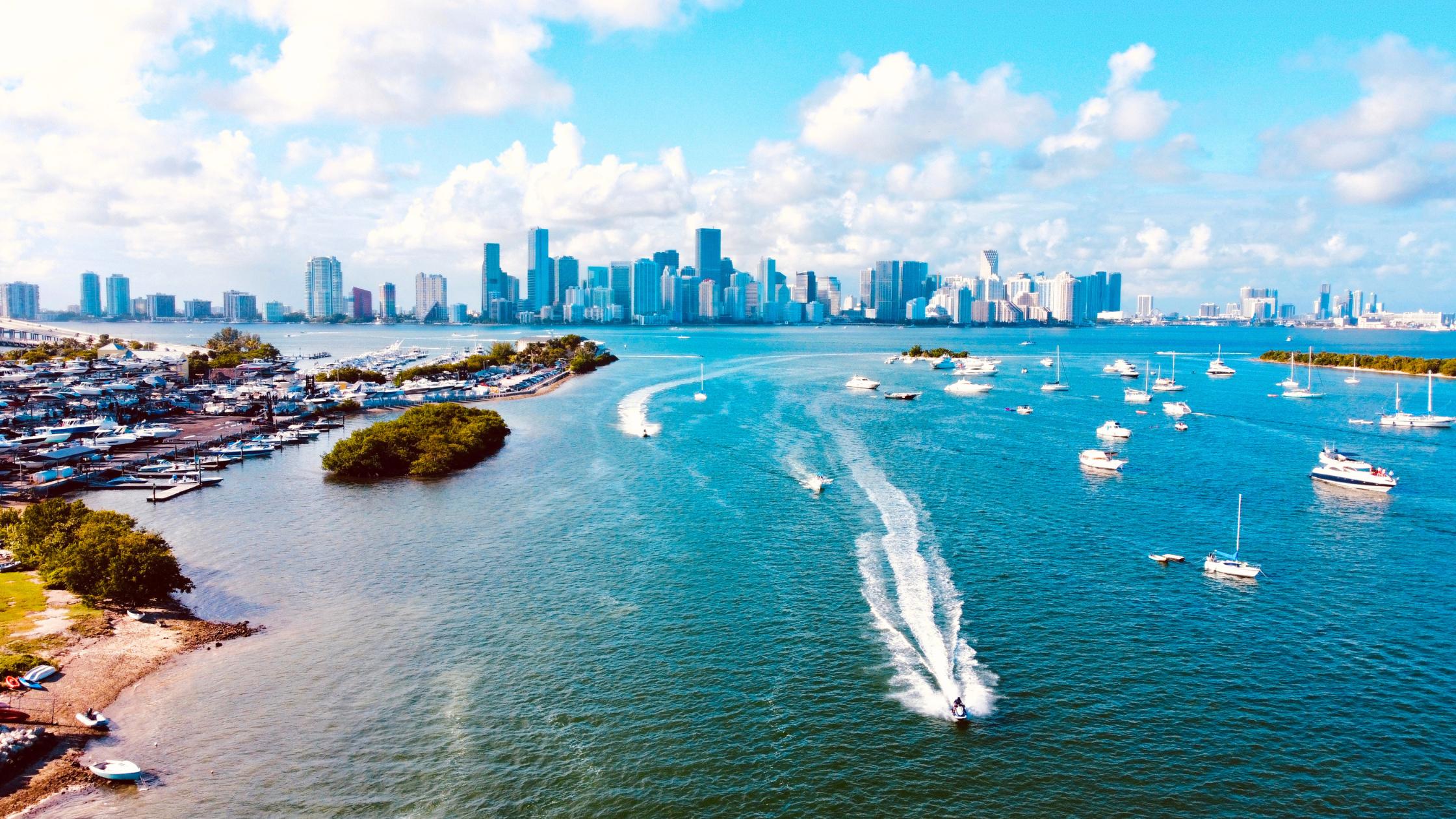 Boating day trips from Miami: center console approaching Stiltsville houses on stilts in Biscayne Bay at golden hour.