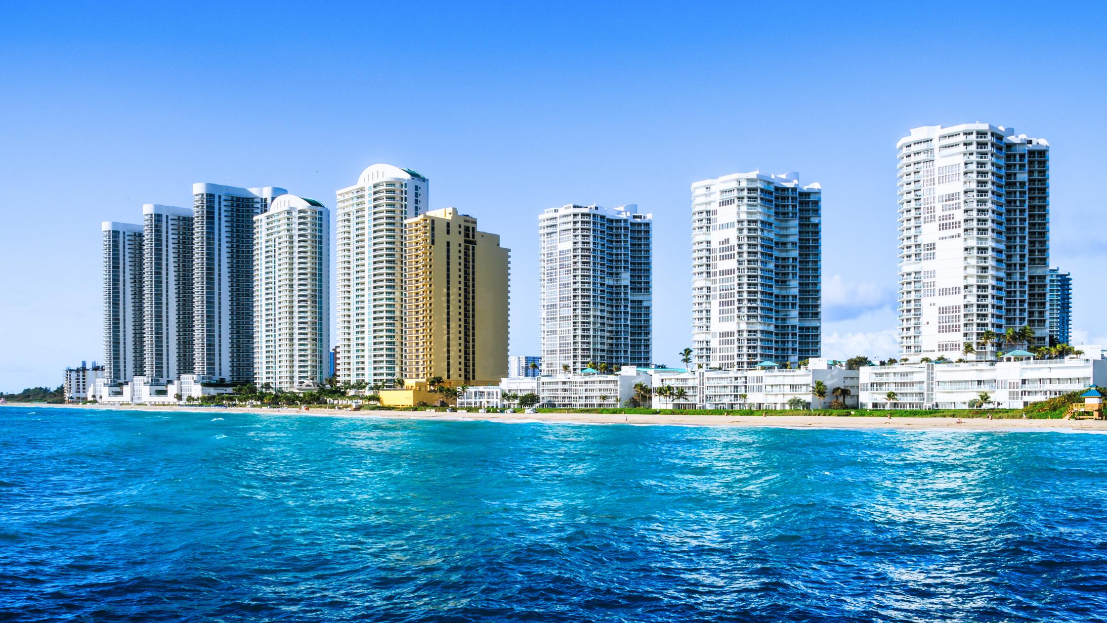 Row of oceanfront luxury condo towers along Collins Avenue in Sunny Isles Beach, key market for selling a home in Sunny Isles Beach