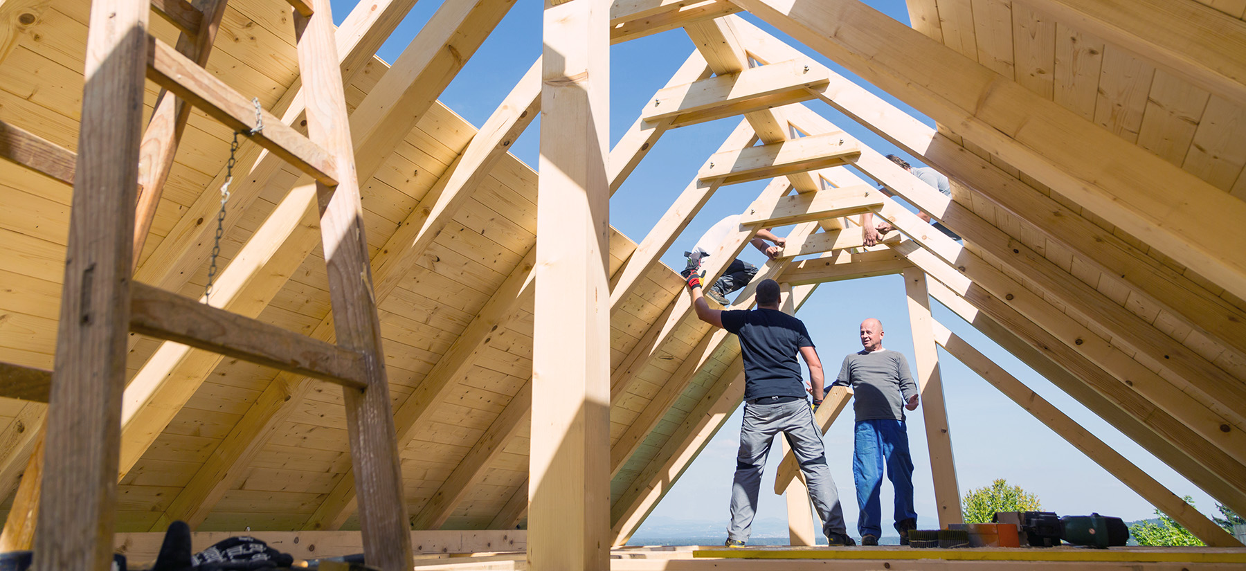 Roof builders mounting prefabricated wooden roof construction. Construction industry concept.