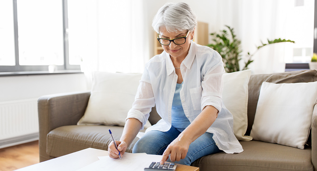 senior woman with money and bills at home