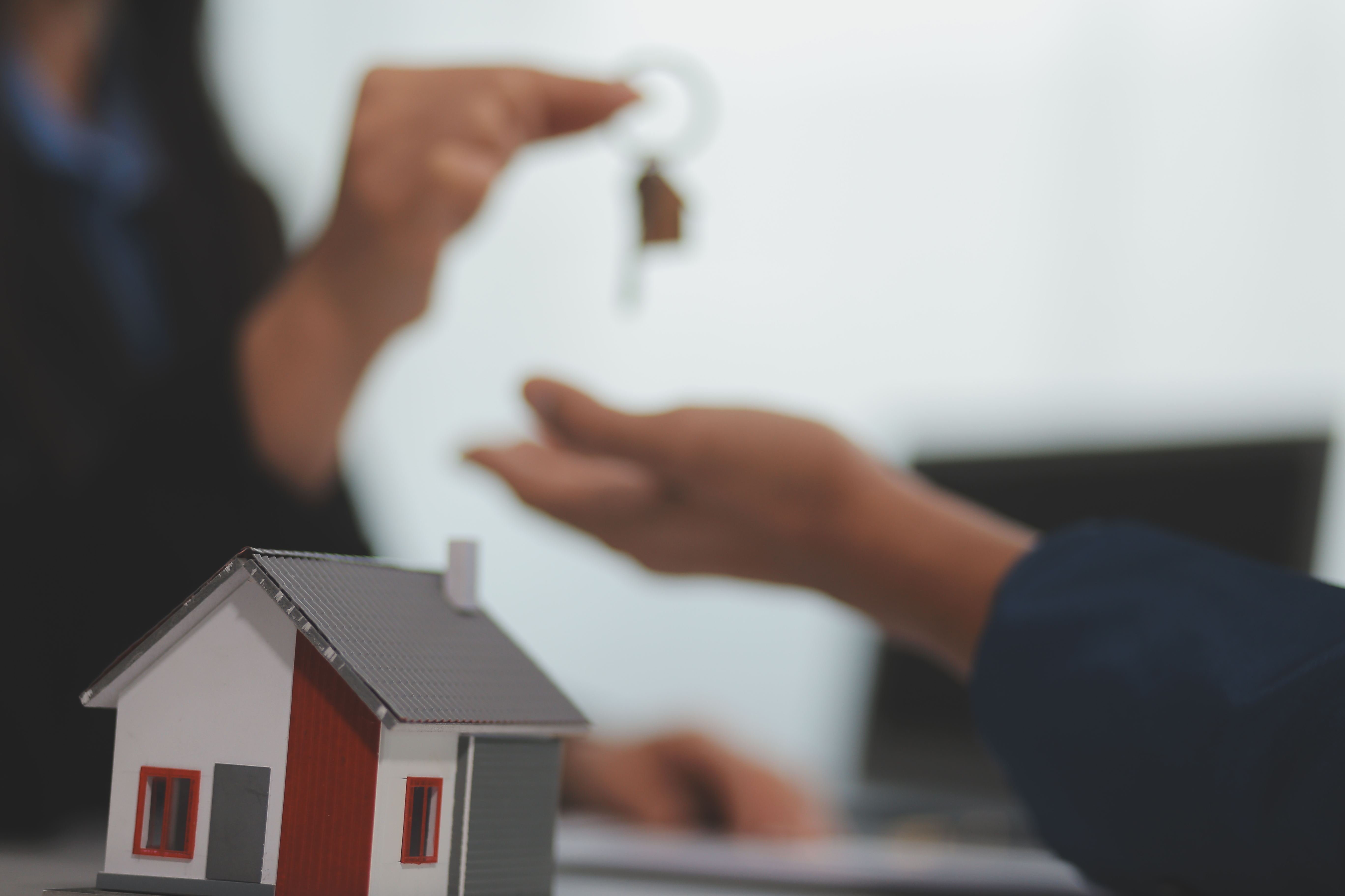 Estate agent giving house keys to client after signing agreement