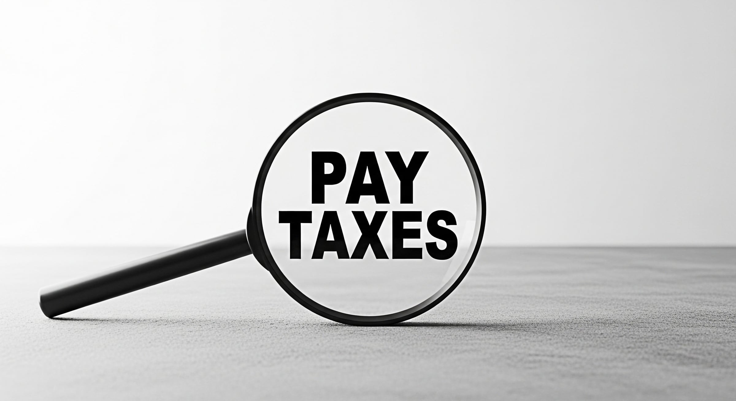 large-vecteezy_magnifying-glass-focusing-on-the-words-pay-taxes-on-a-gray_73744945_large