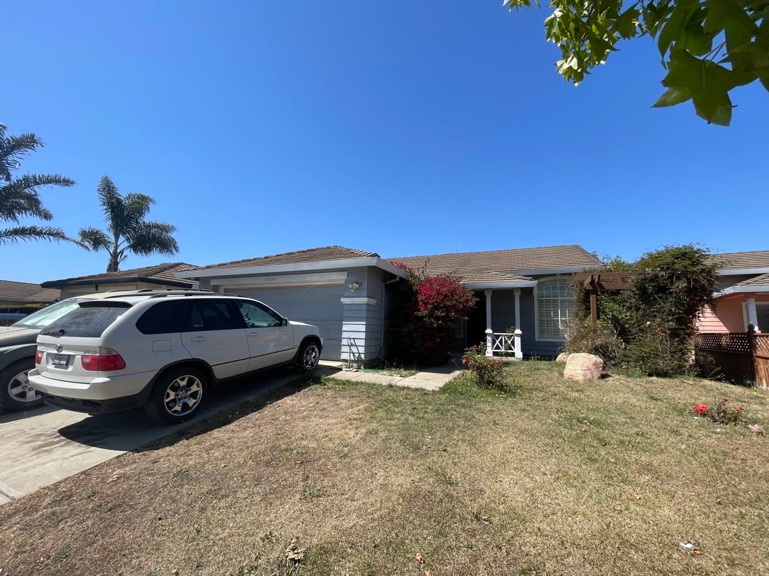 Front of the house before: dead lawn and a parked SUV