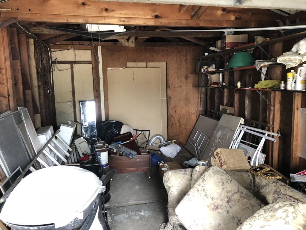 Before: the garage packed with old furniture, a lawn mower, window screens and paint cans