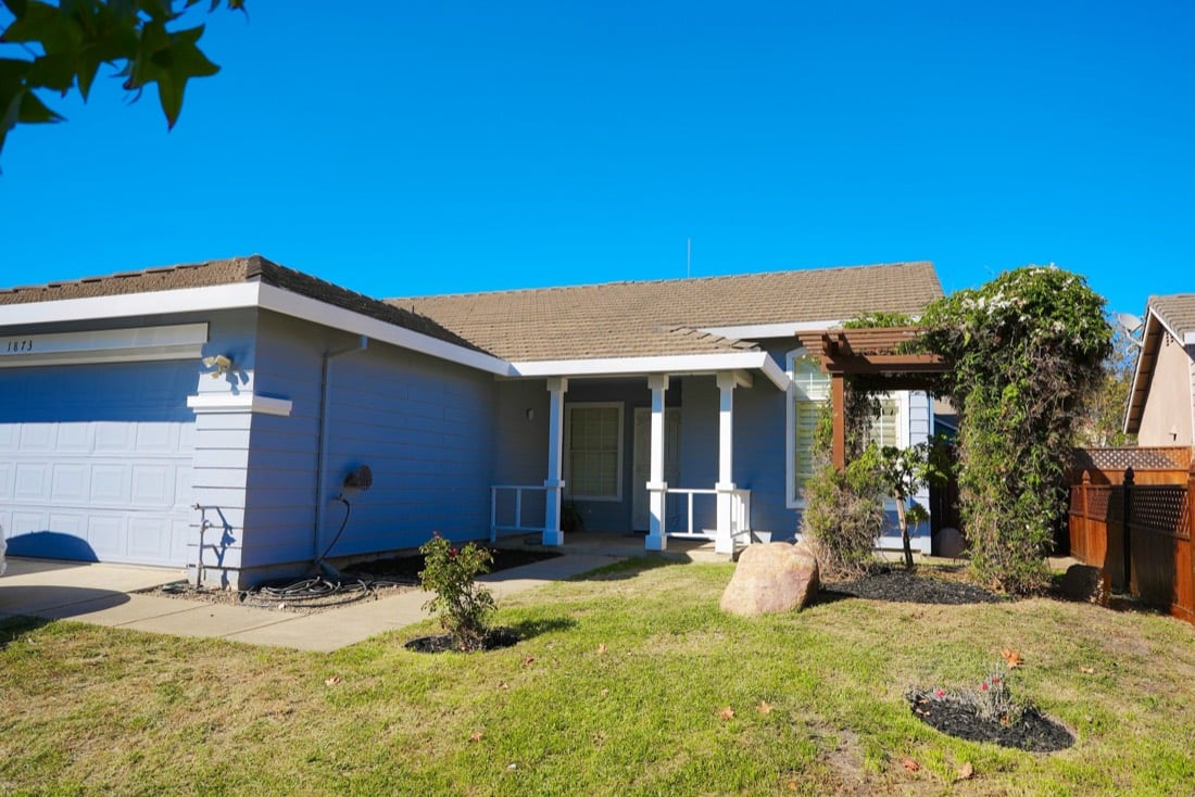 Front of the house after: green lawn, mulched beds, clear driveway