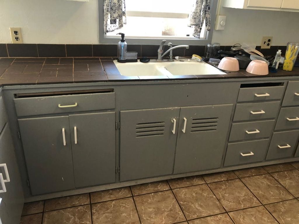 Before: cottage kitchen counter, where a lifted tile exposed rotted wood