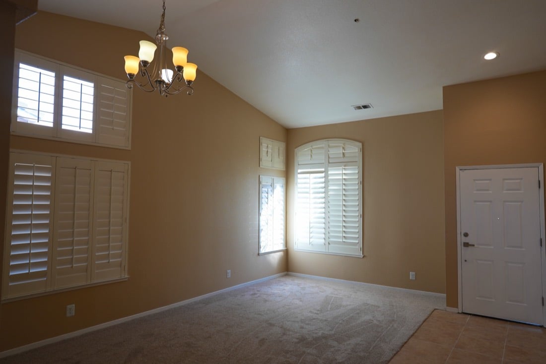 Living room after: empty, vaulted ceiling, new carpet