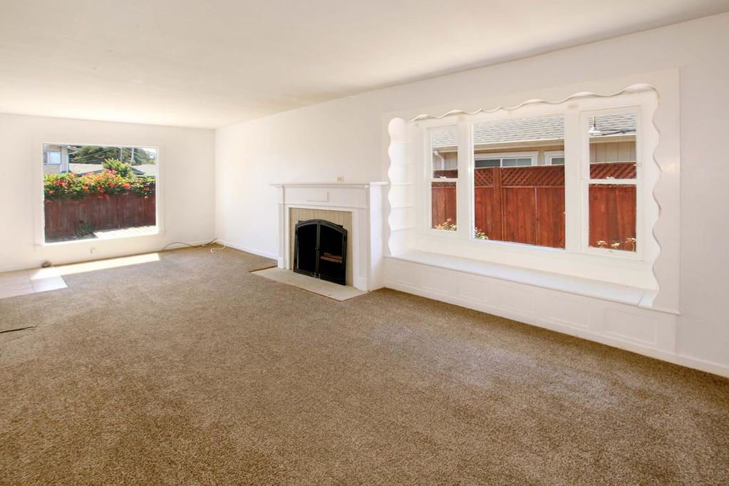Main house living room with fireplace and large windows