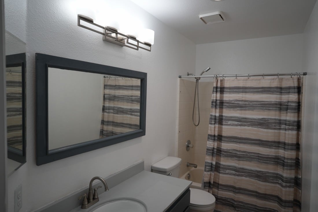 Hall bath after: white walls, new mirror and light