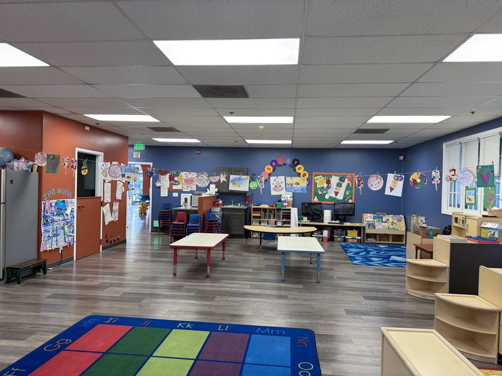 Children’s artwork strung across the preschool room, with a doorway leading toward the adult day program at Hearts & Minds in San Jose