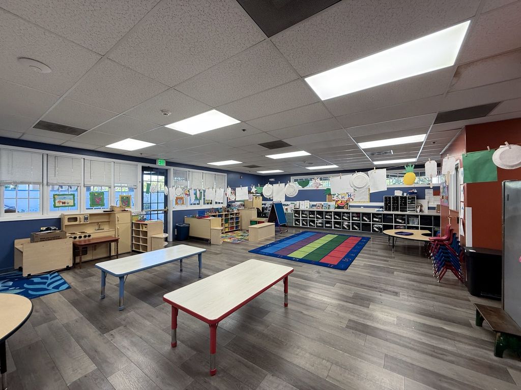 Licensed preschool classroom with an alphabet rug, play kitchen and cubbies at Hearts & Minds Activity Center in San Jose