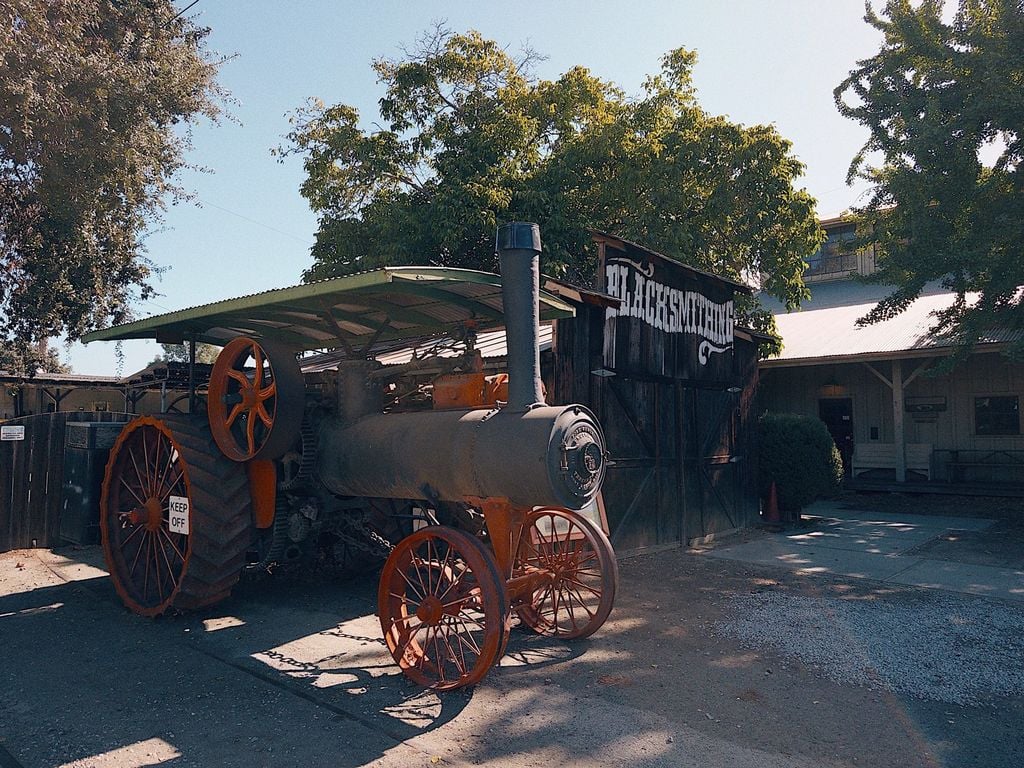 Antique steam traction engine outside the blacksmith shop at History Park San Jose